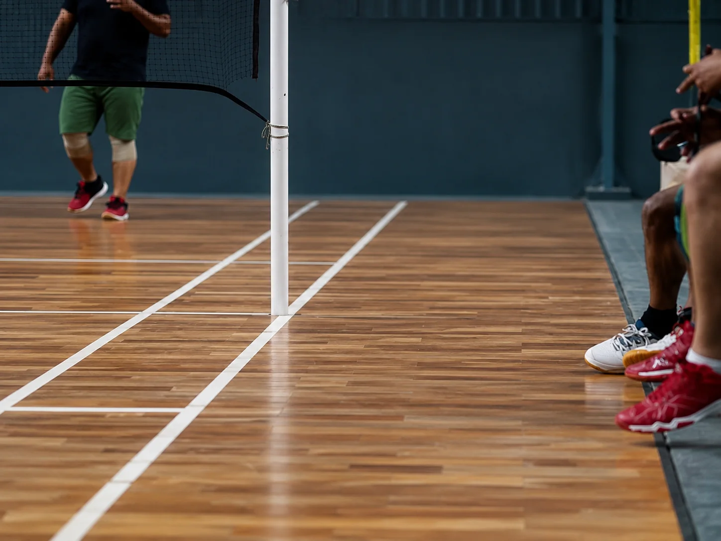 Teak court flooring beside the indoor player bench