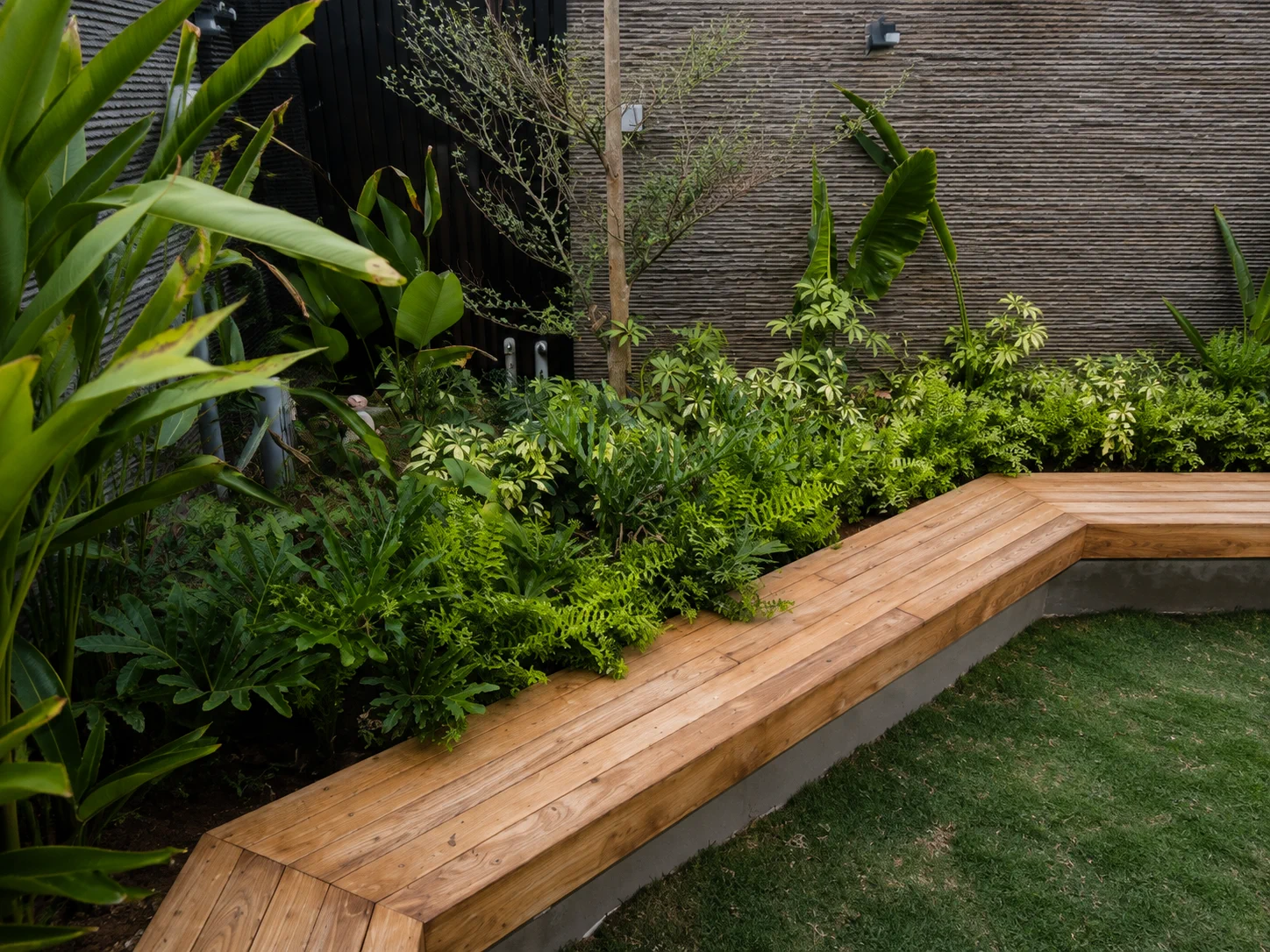 Built-in teak garden bench wrapping a landscaped courtyard