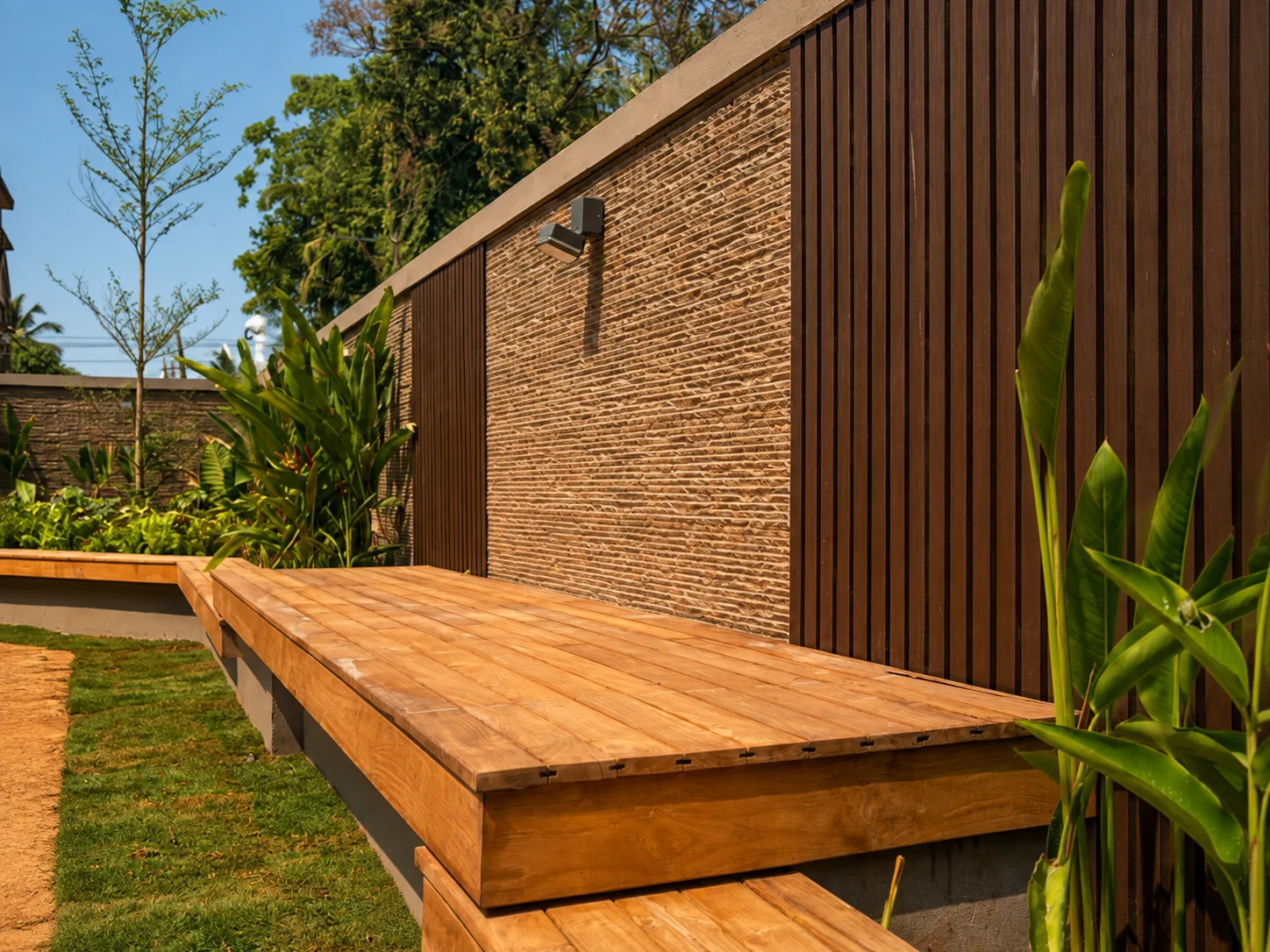 Raised teak deck platform integrated into a tropical garden